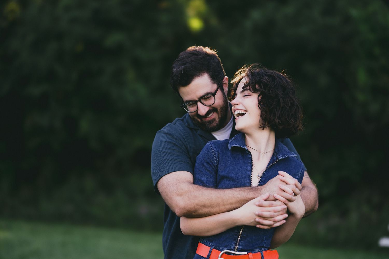 A couple embracing and laughing together in an outdoor setting.