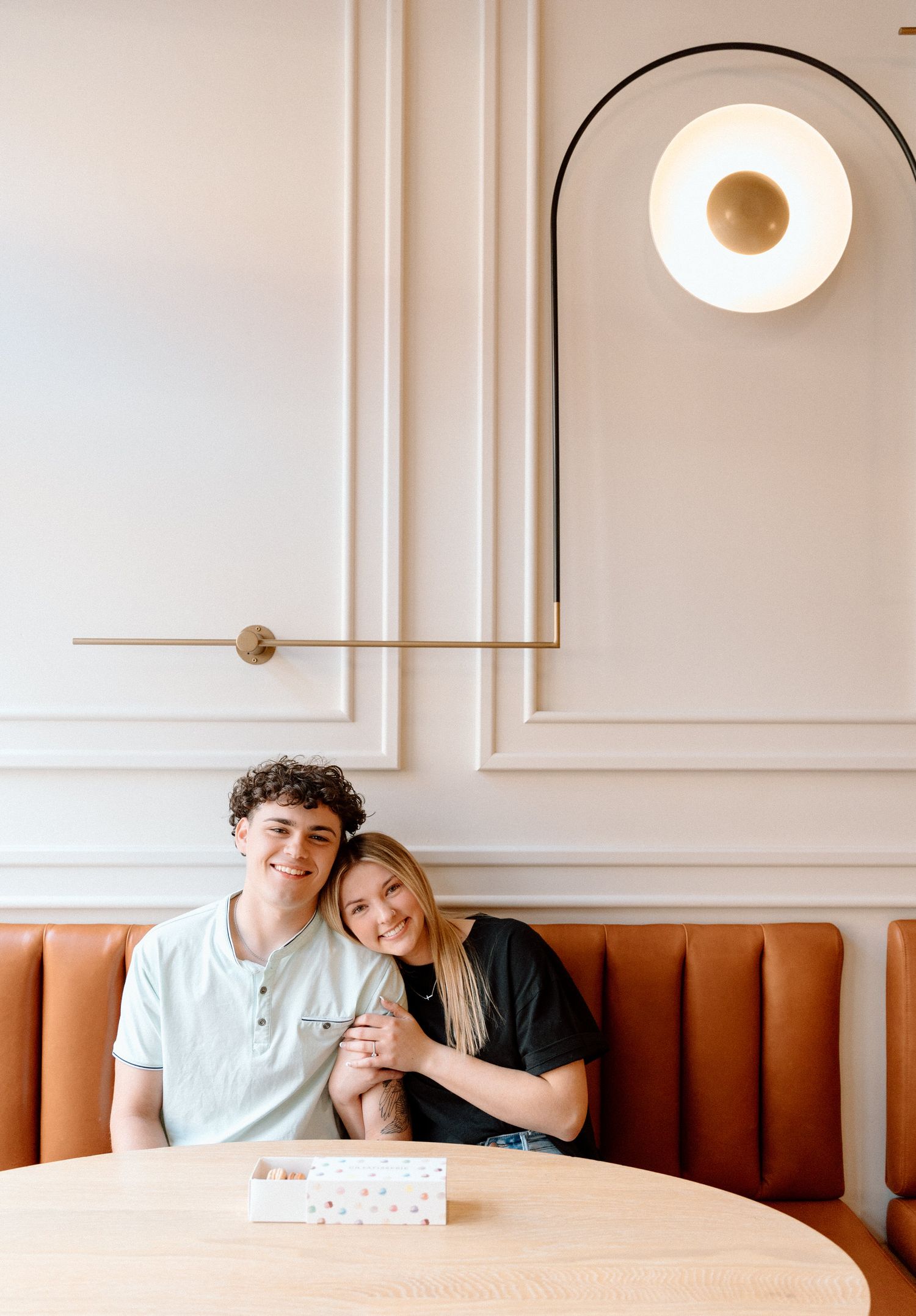 Modern restaurant interior with orange booth seating and minimalist lighting fixtures.