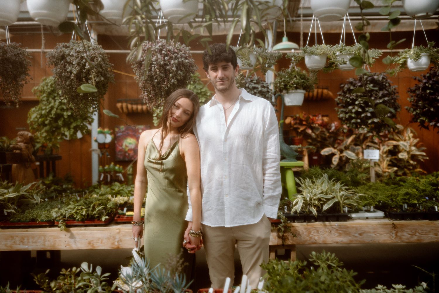 Romantic greenhouse photoshoot with plants and Christmas decorations.