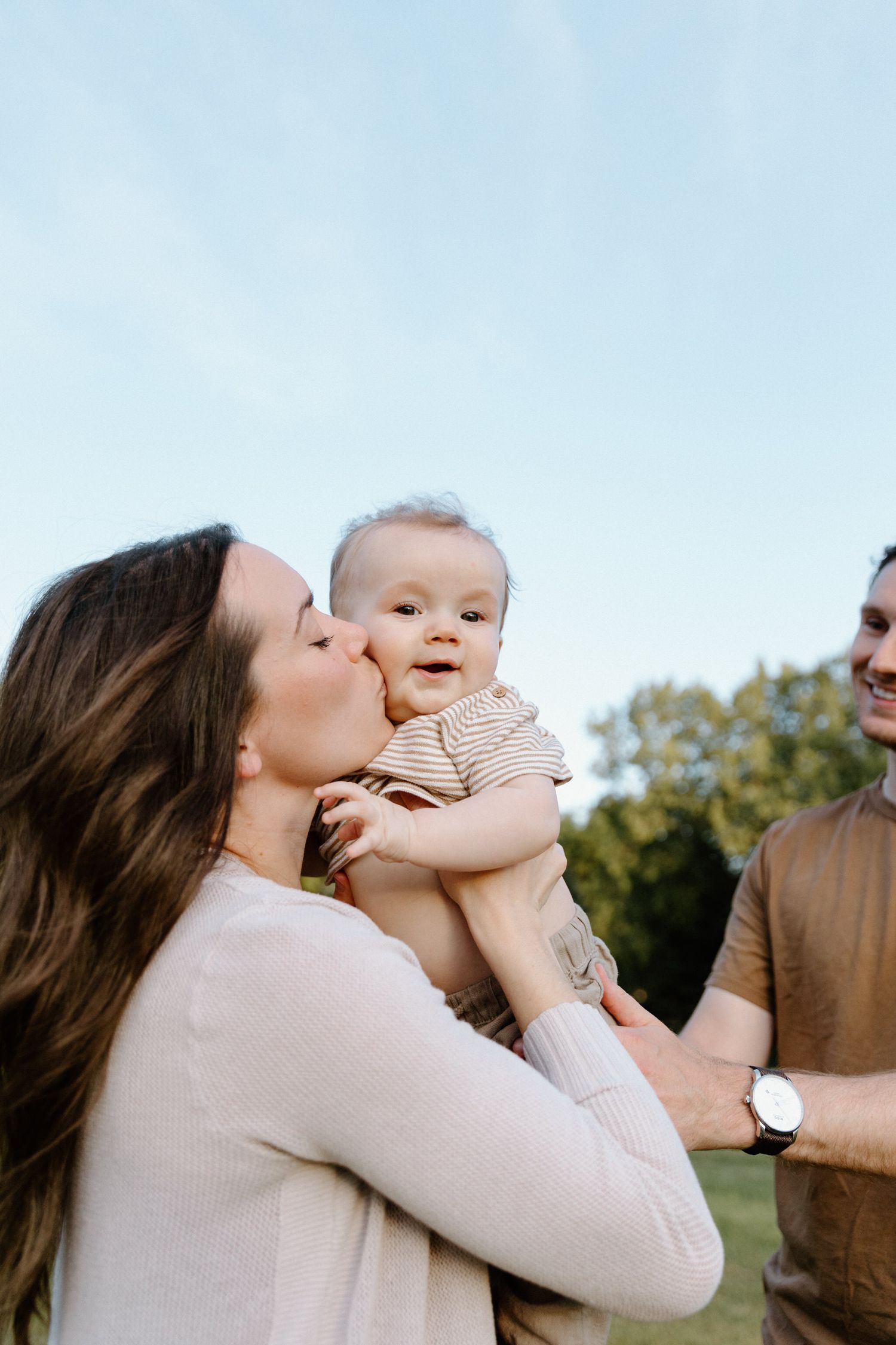Sweet outdoor moments between parent and baby during a family photoshoot.