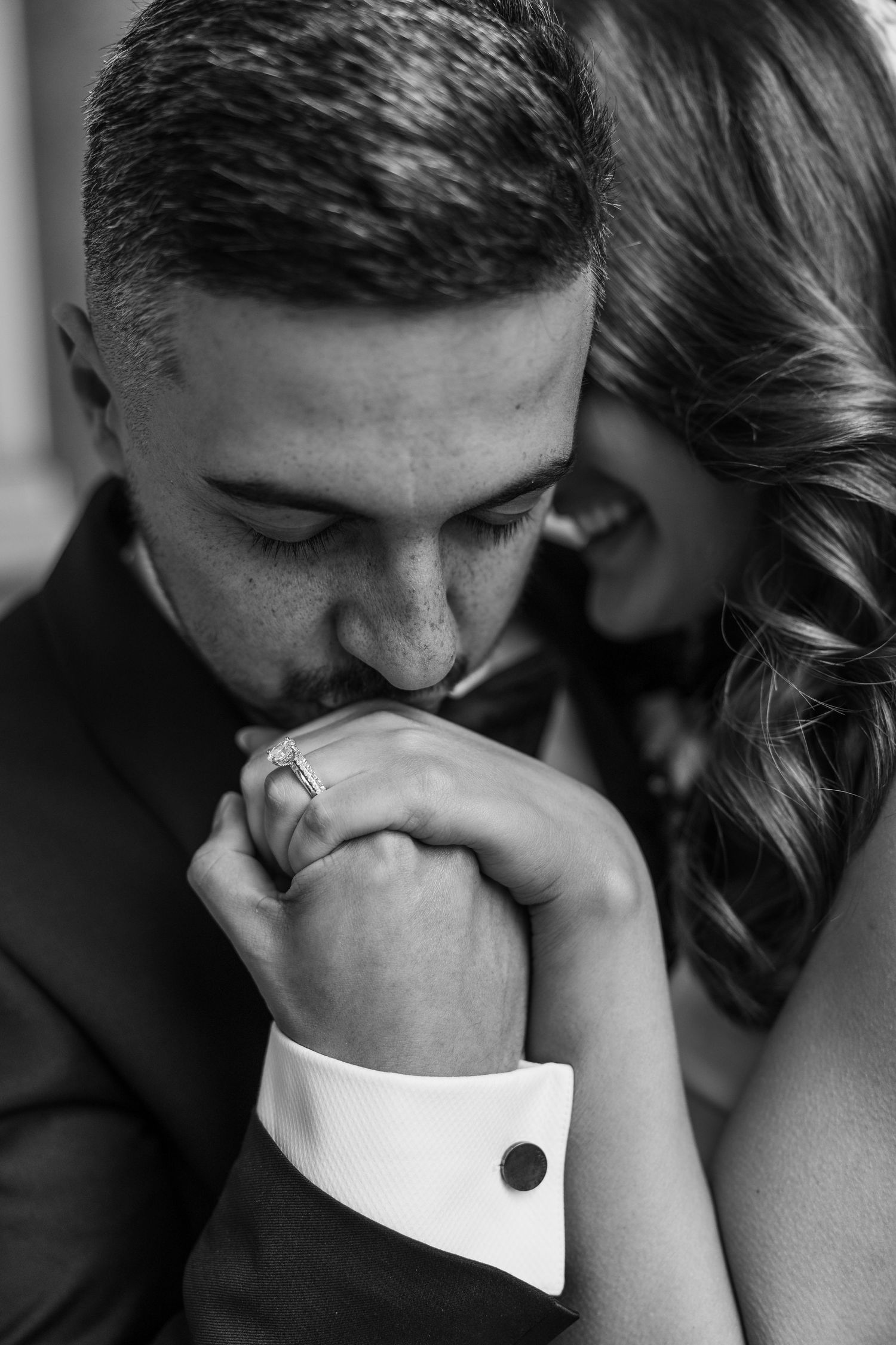Intimate black and white close-up of couple sharing a tender moment.