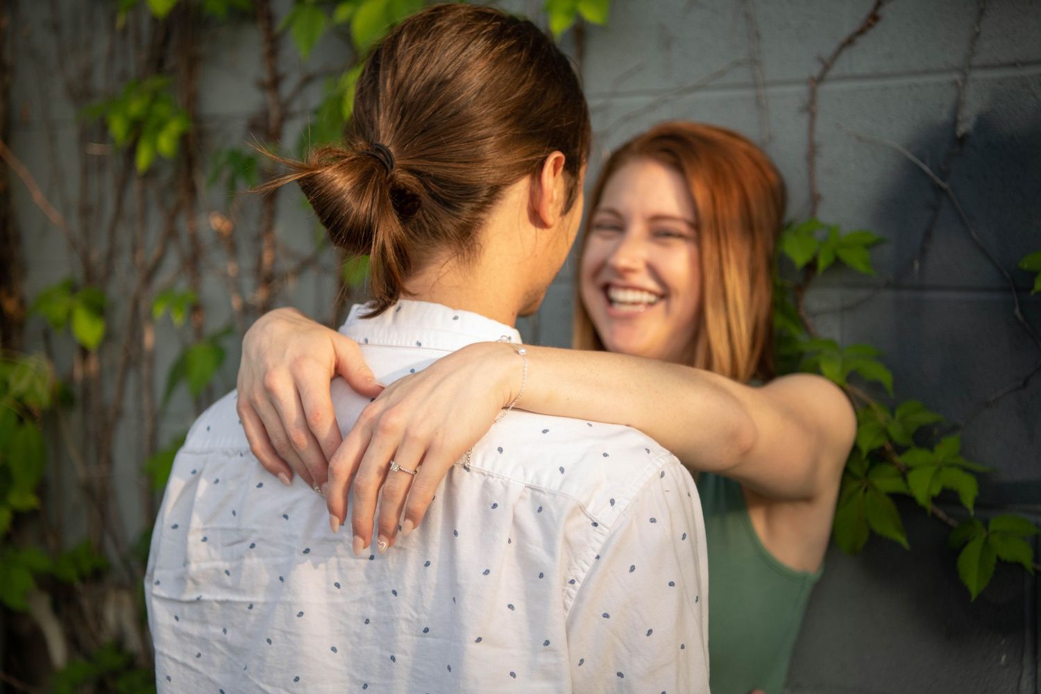 A tender moment shared between a couple surrounded by lush greenery.