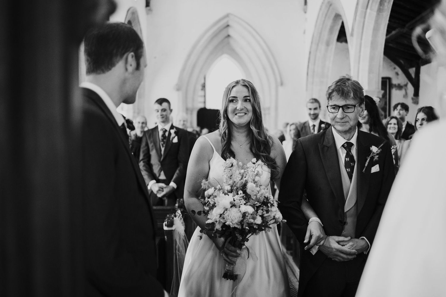 A wedding ceremony taking place inside a beautiful gothic church.