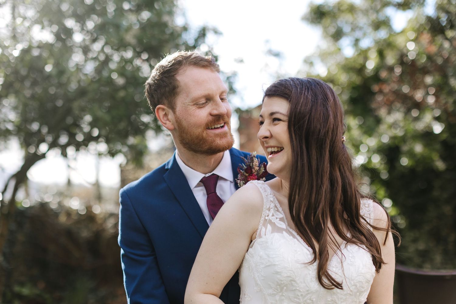 A joyful moment shared between a couple in formal attire outdoors.