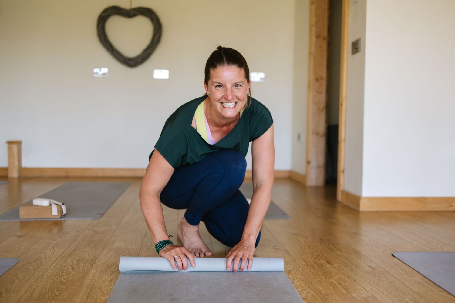 Exercise scene with yoga mat being rolled out on wooden floor.