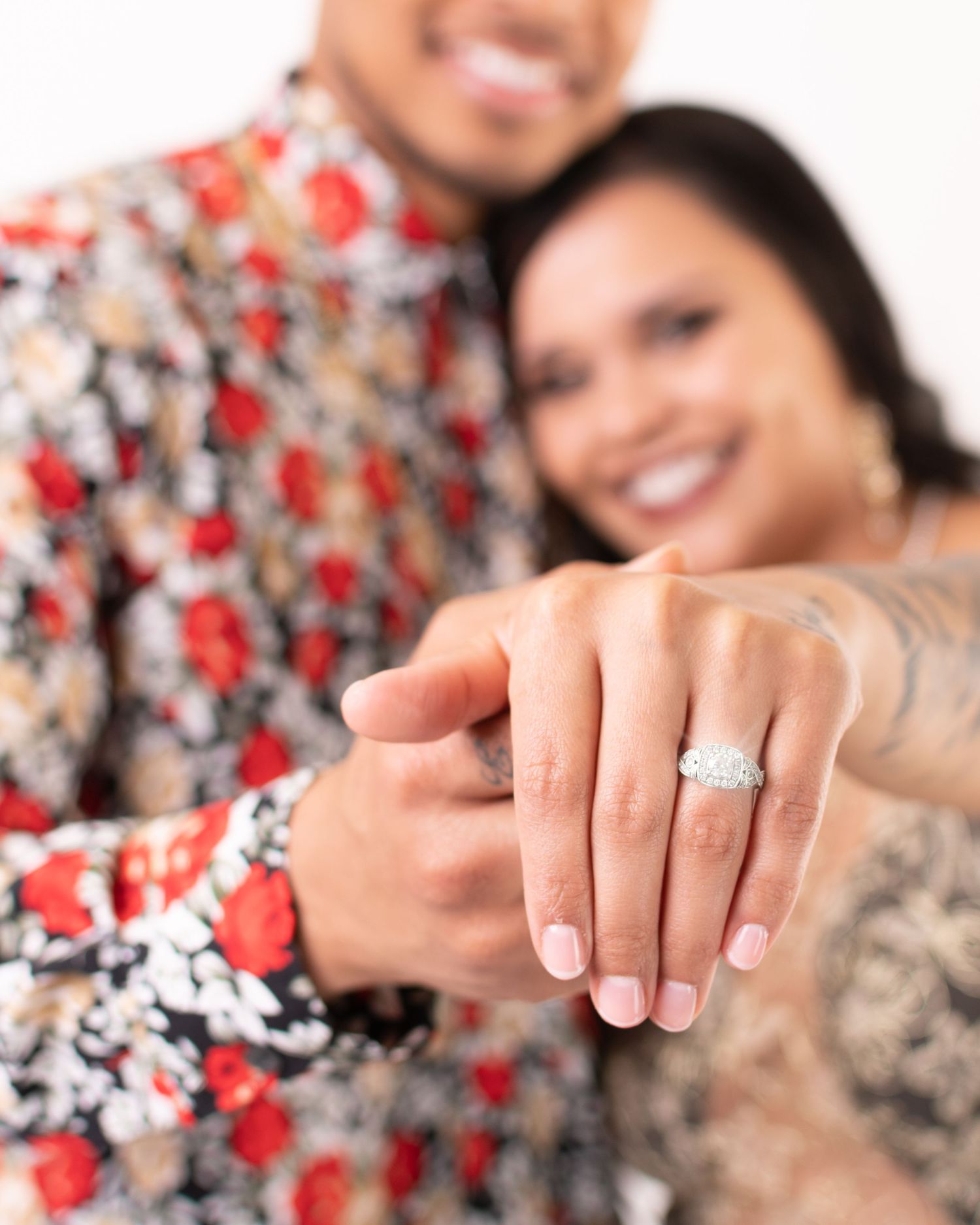 Close-up sequence of hands showing engagement ring against floral background.