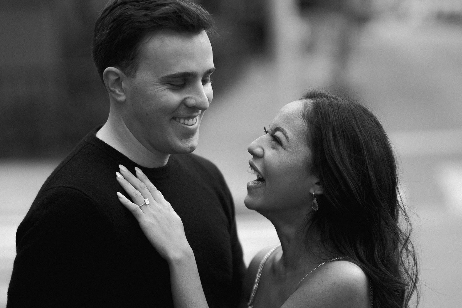 Black and white portrait of a couple sharing a tender laughing moment together.