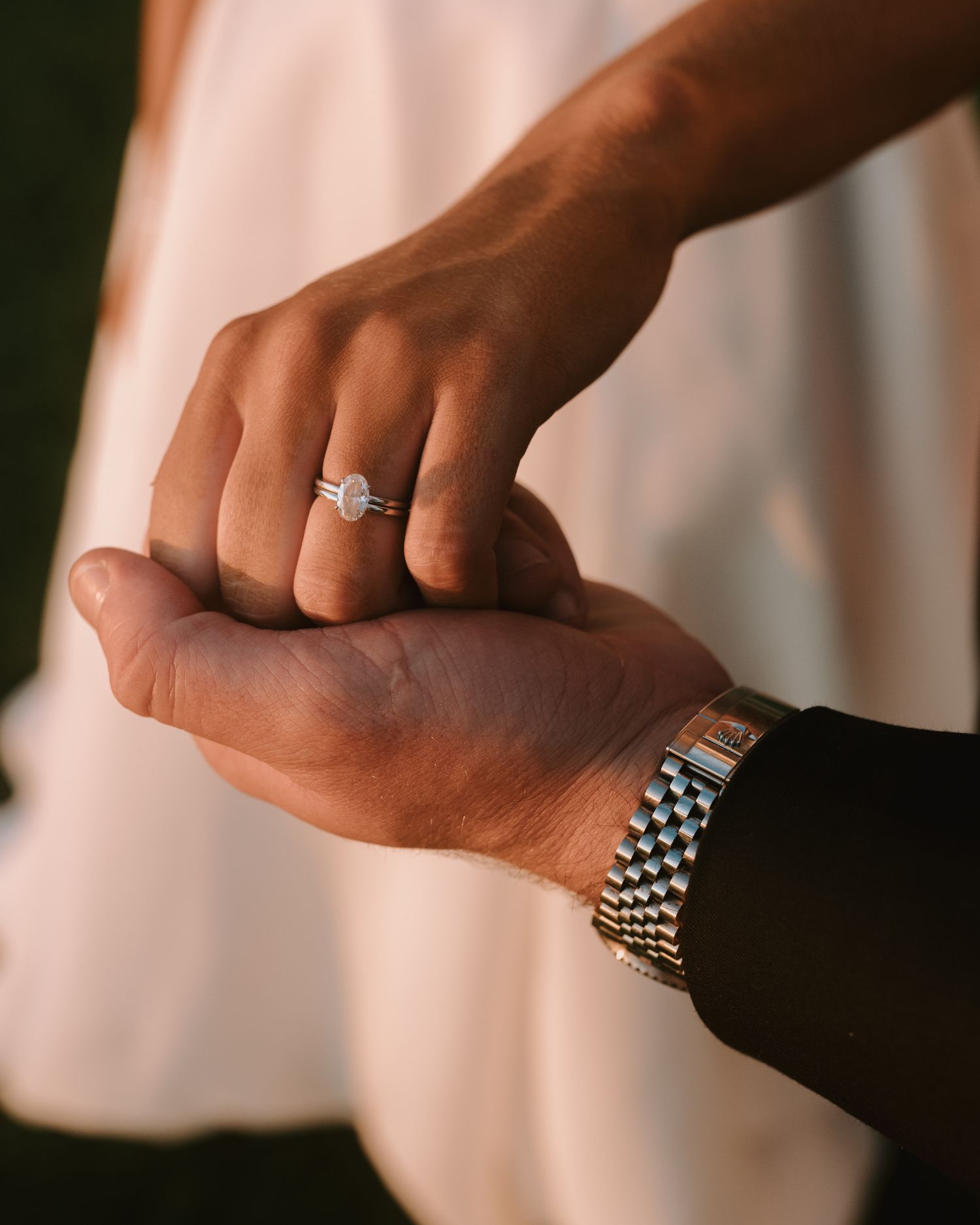 Close-up of hands showcasing elegant wedding rings and jewelry.