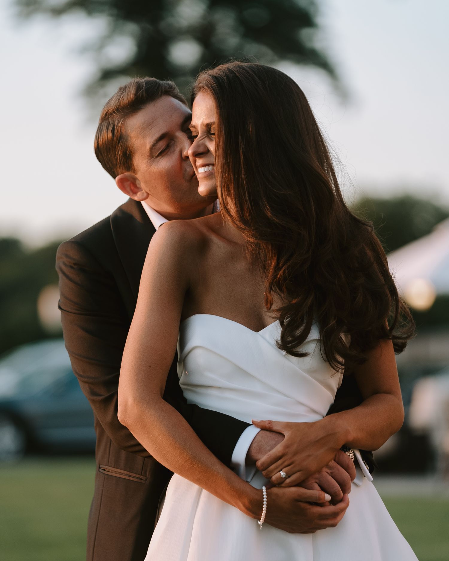 A tender romantic moment captured during an outdoor wedding celebration.