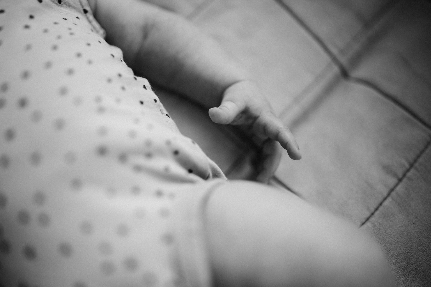 Close-up black and white image of tiny hand reaching out.