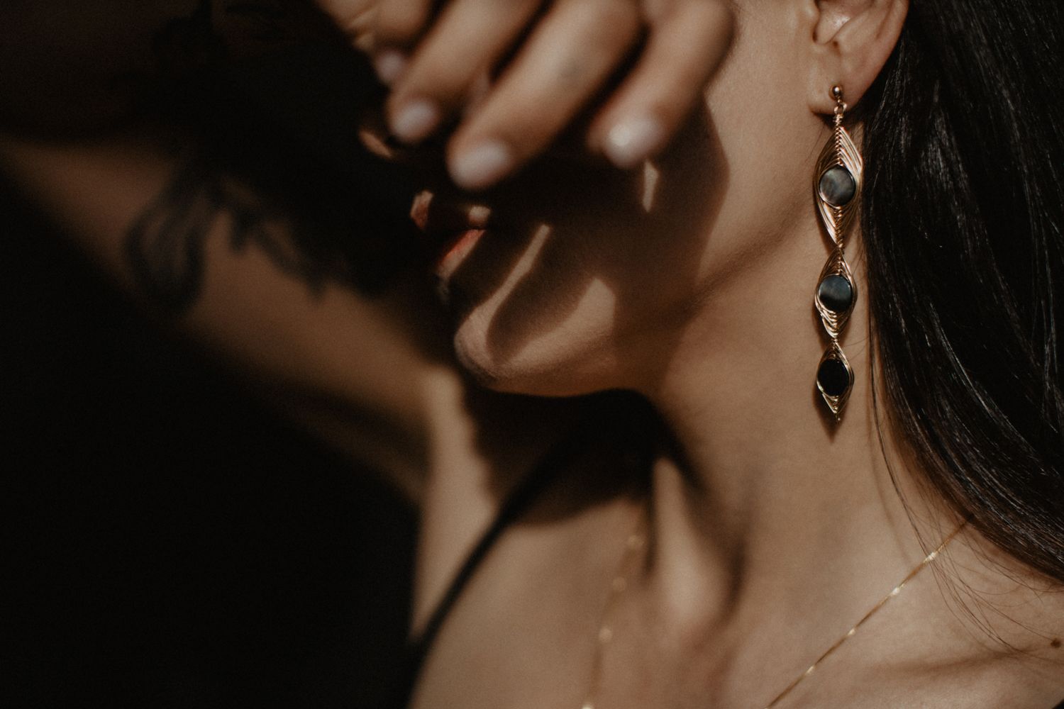 Detailed shot of twisted crystal drop earring with dramatic shadows.