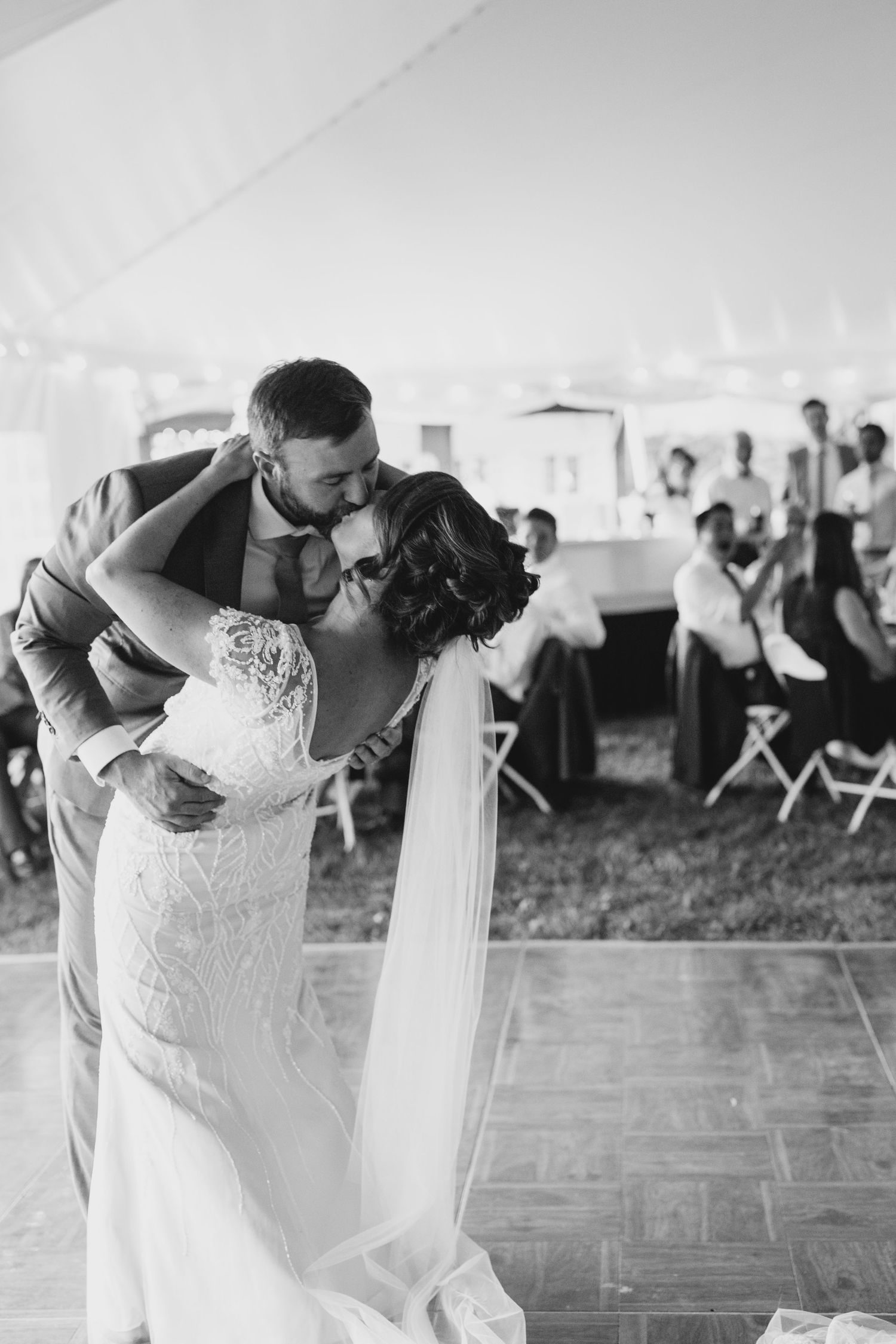 A couple shares a romantic dance under a white tent at their wedding celebration in Stowe, Vermont