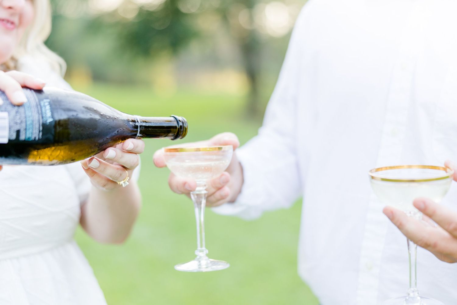 Detail shots of champagne being poured into glasses during an outdoor celebration.