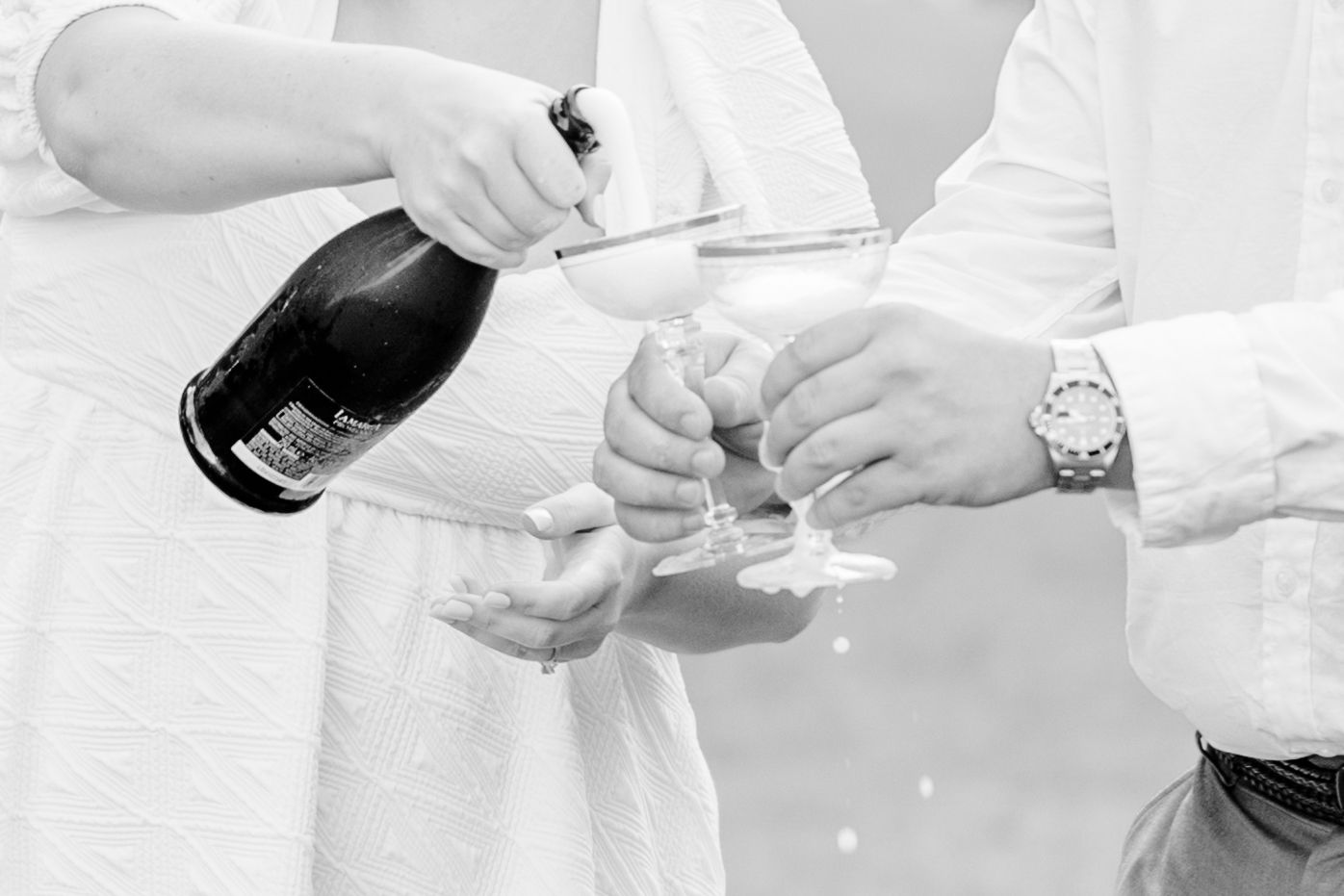 Close-up shots of hands opening and pouring champagne into glasses.