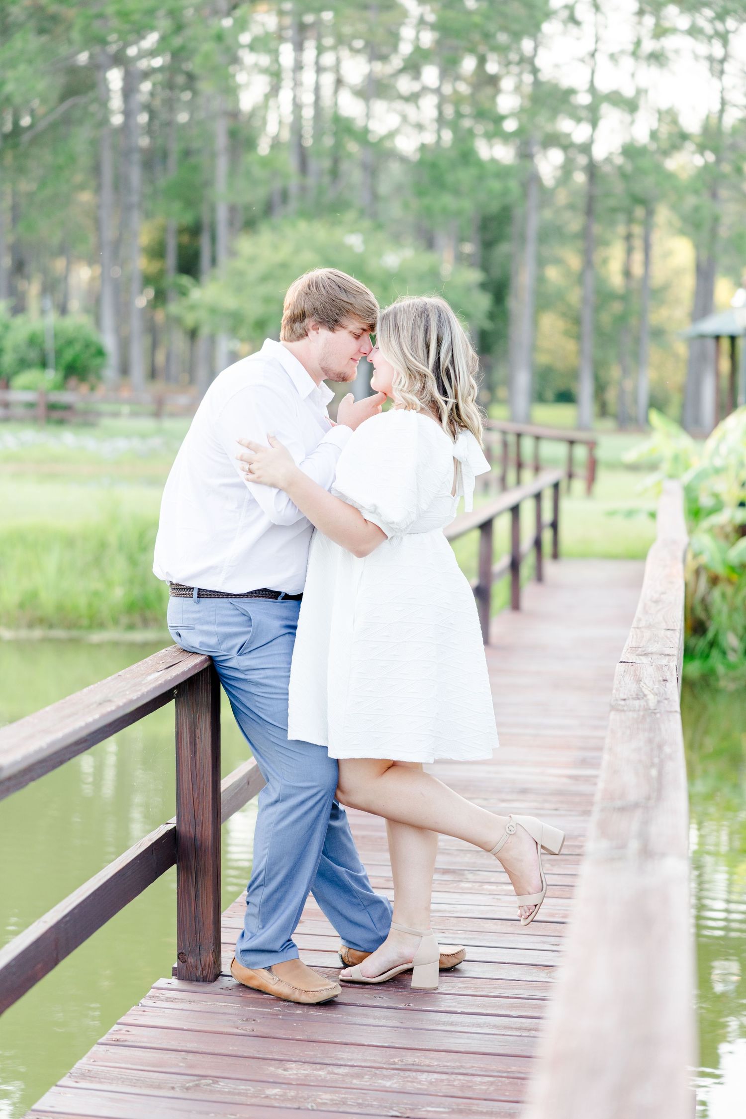 Romantic sequence of a couple embracing on a lakeside boardwalk in summer attire.