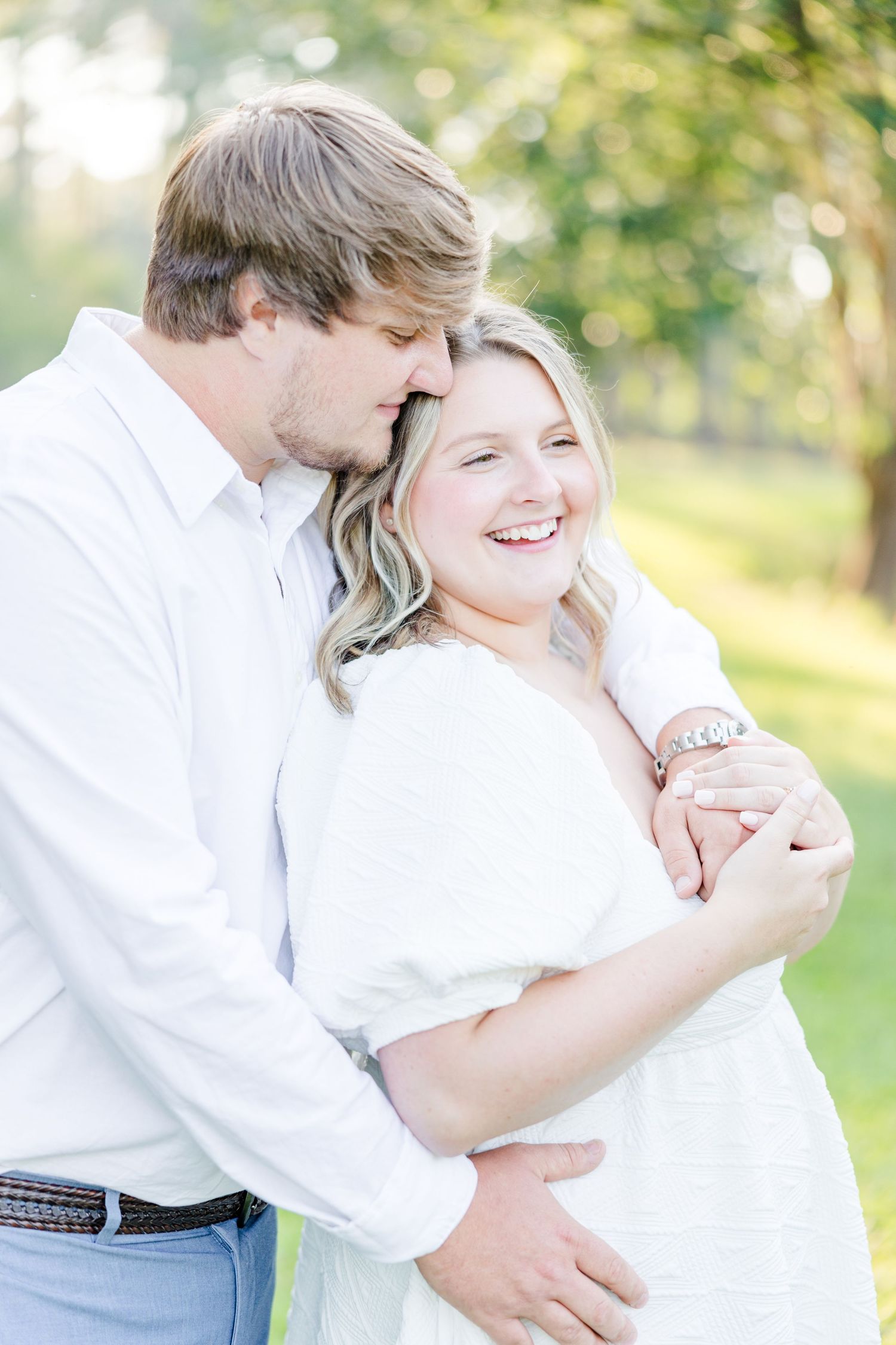 Couple shares loving embraces during their outdoor engagement photo session.