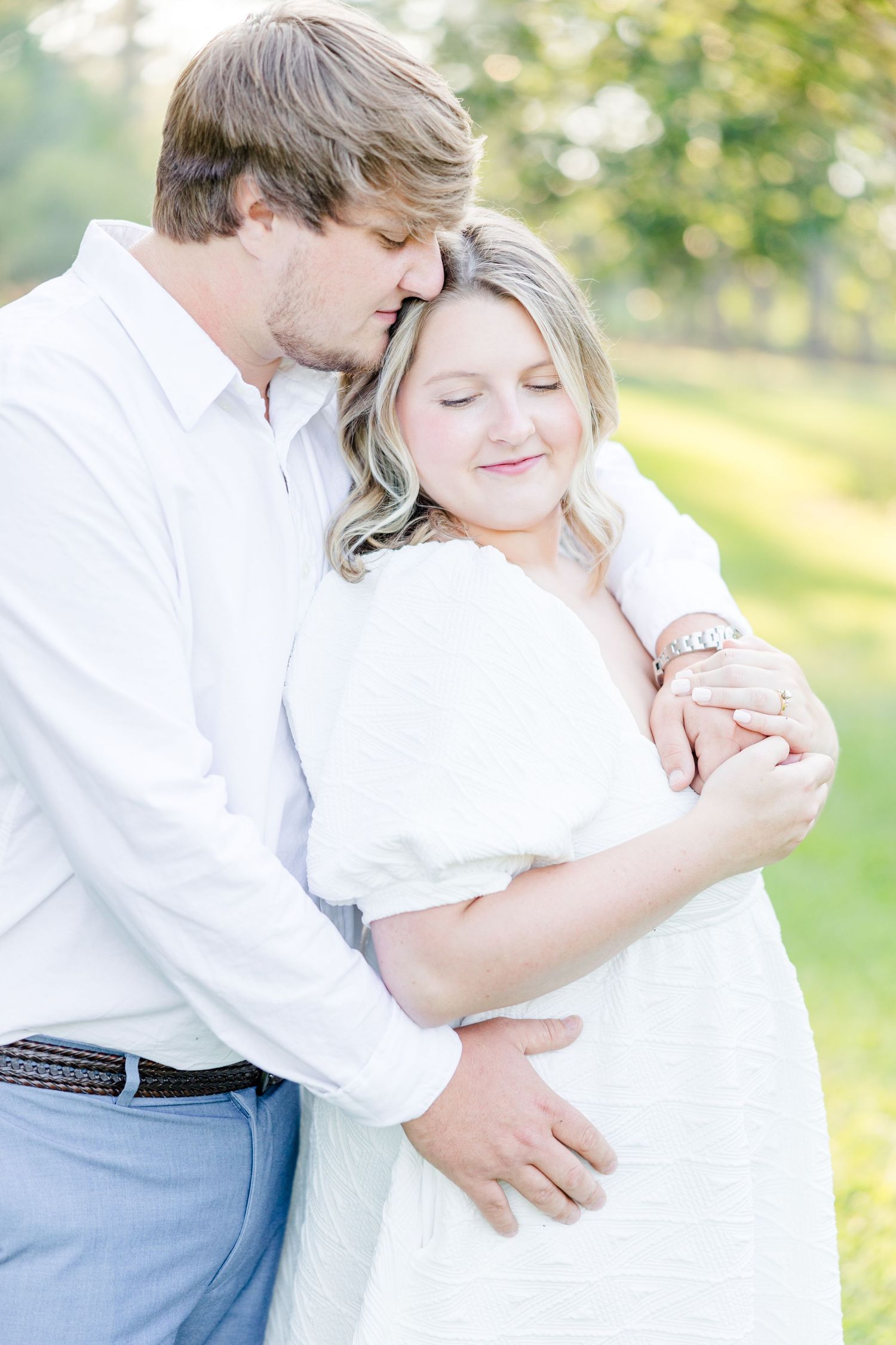 Tender moments captured between a couple during their engagement session in a park setting.