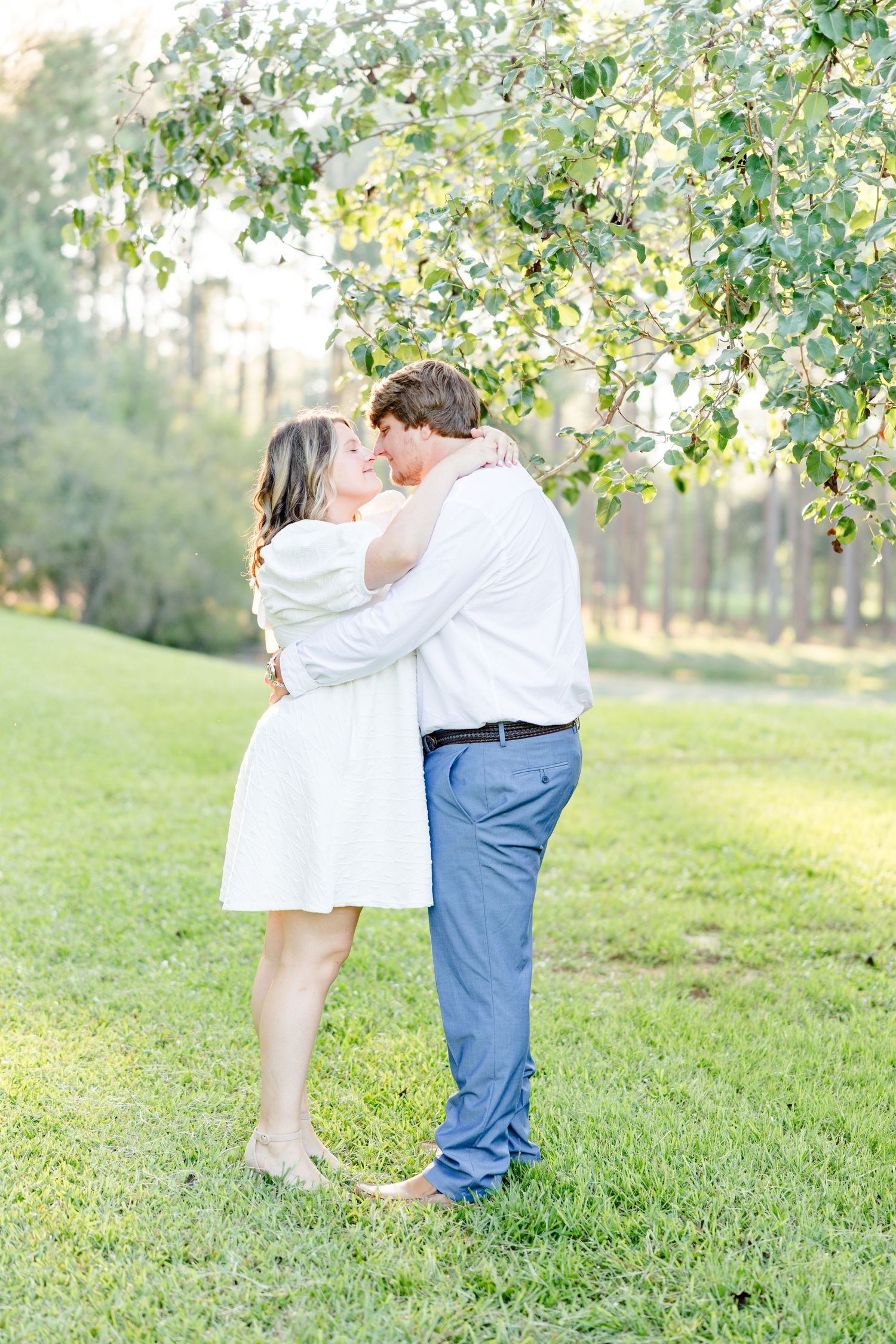 Romantic outdoor engagement photos of a couple embracing in a serene park setting.