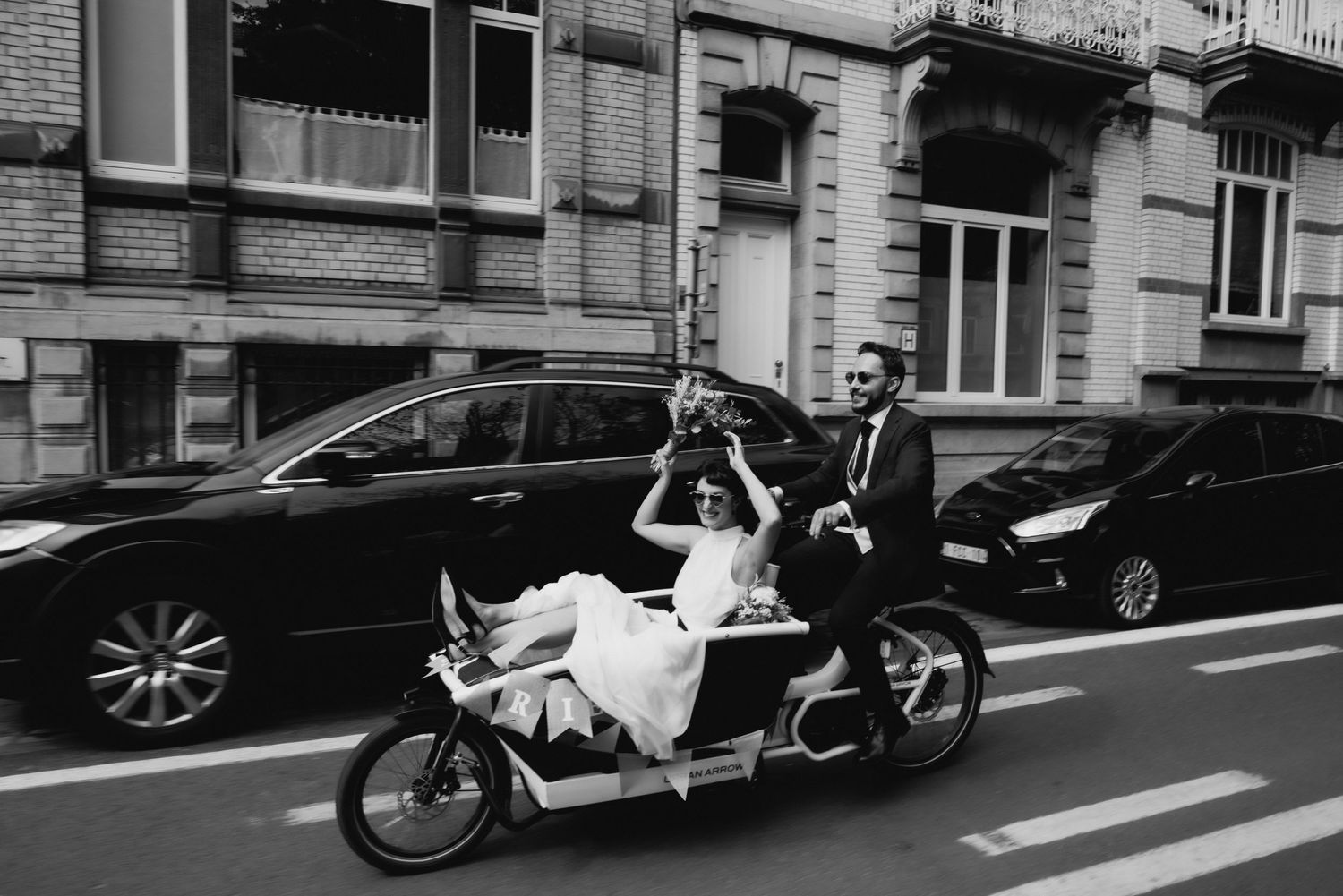 bride and groom in cargo bike riding around Brussels wedding photographer trouwfotograaf
