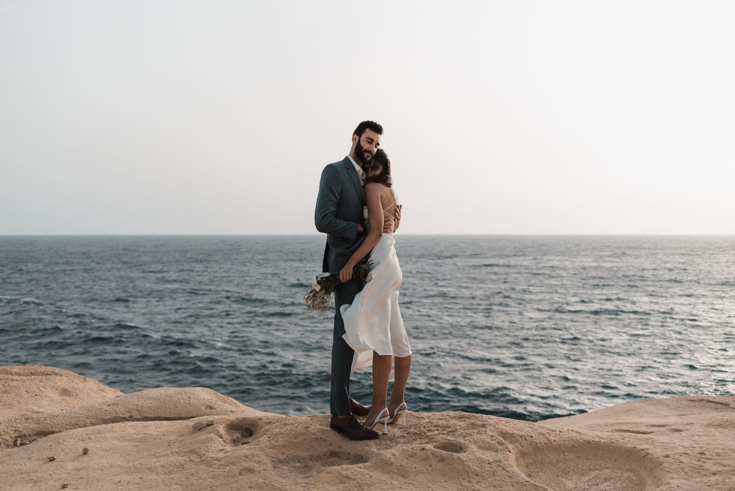 bride and groom hugging sea horizon malta gozo elopement wedding photographer Europe Italy fotograaf