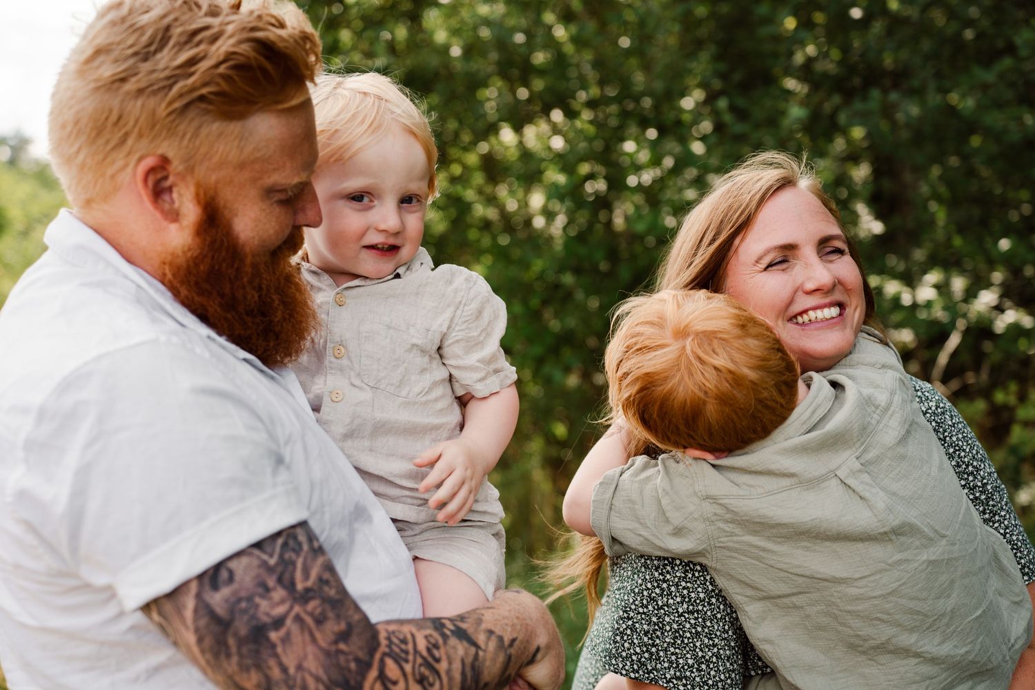 A happy family shares a joyful moment together outdoors on a sunny day.