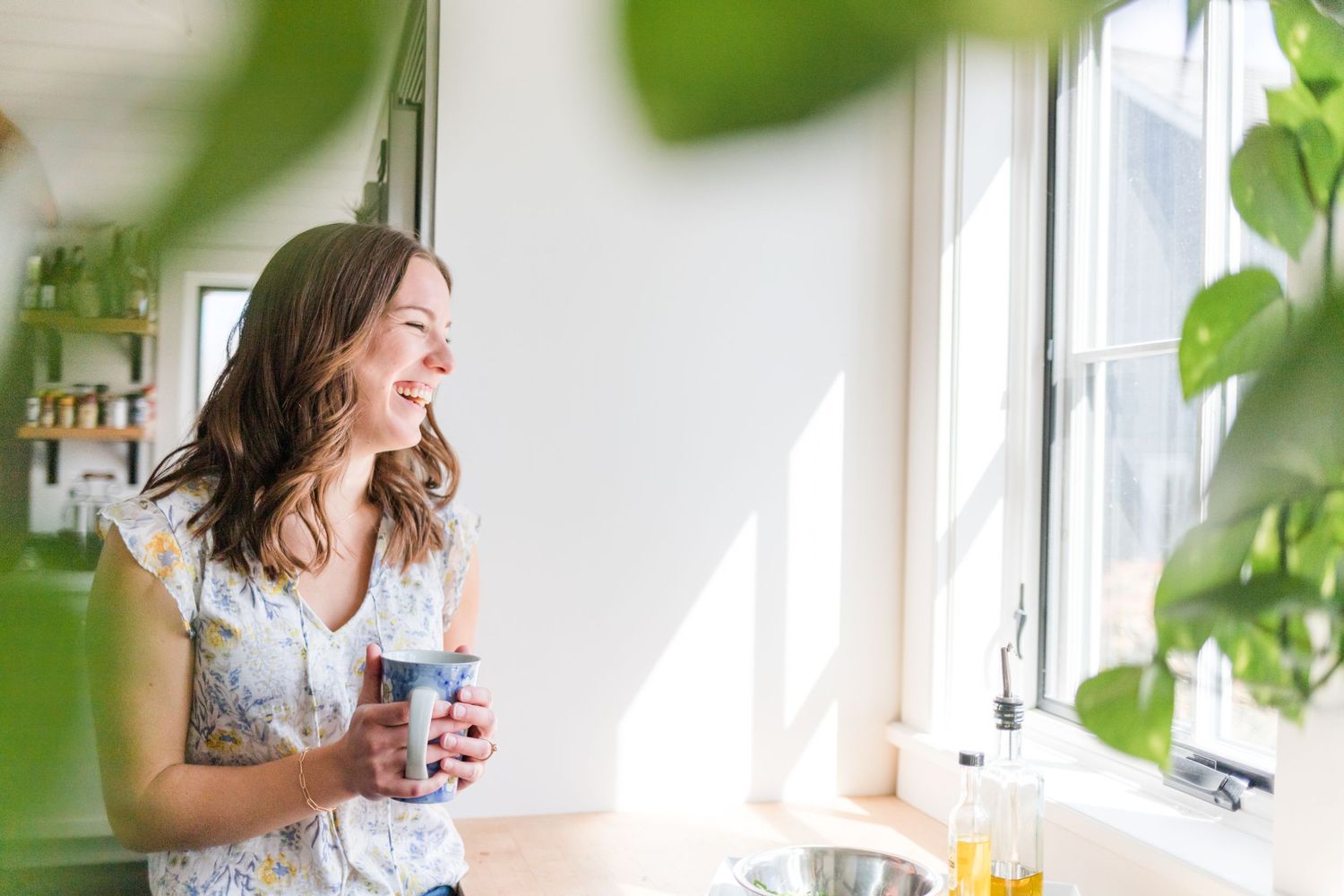 Girl laughing in a white farmhouse kitchen during a brand session at Watergrasshill Bed + Breakfast in New Paltz, NY