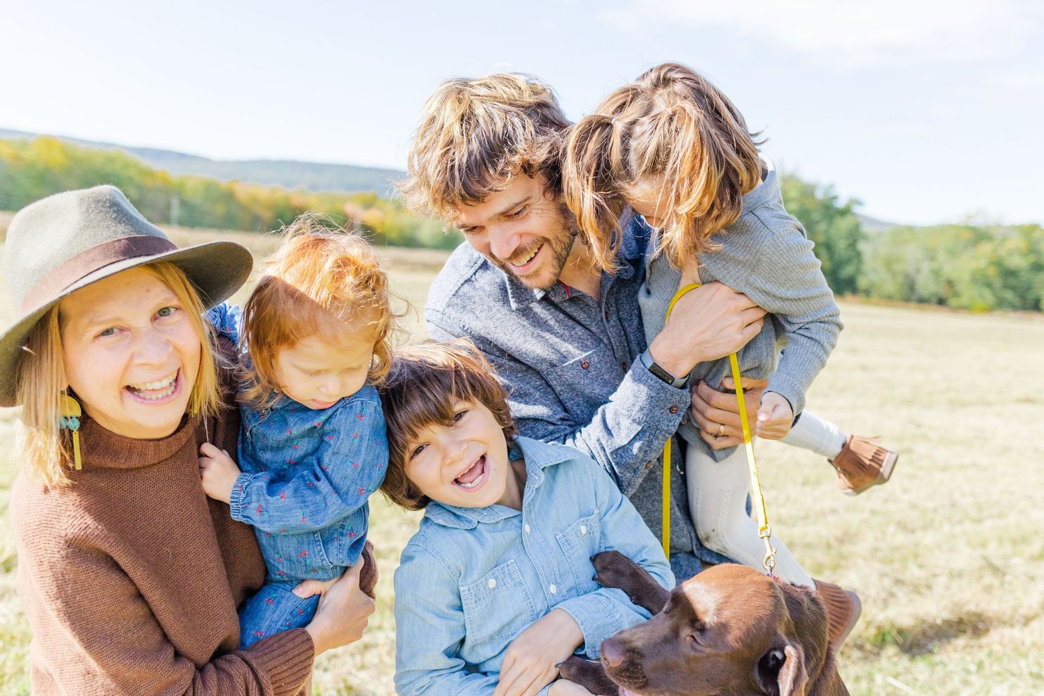 Family of 5 smiling dressed in earth tones during a fall family session in the Hudson Valley of New York
