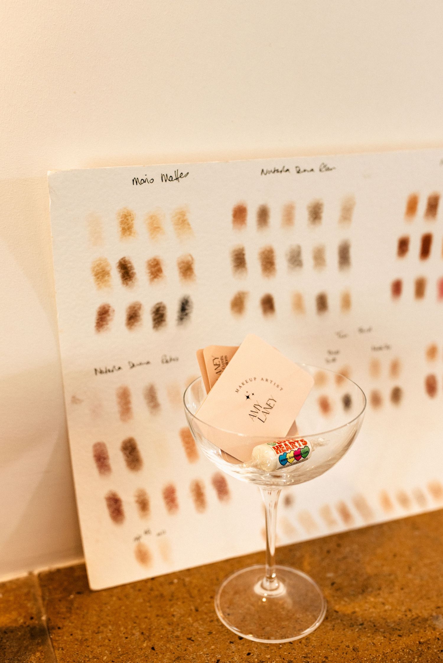 Martini glass with color swatch board display in background showing various brown tones.