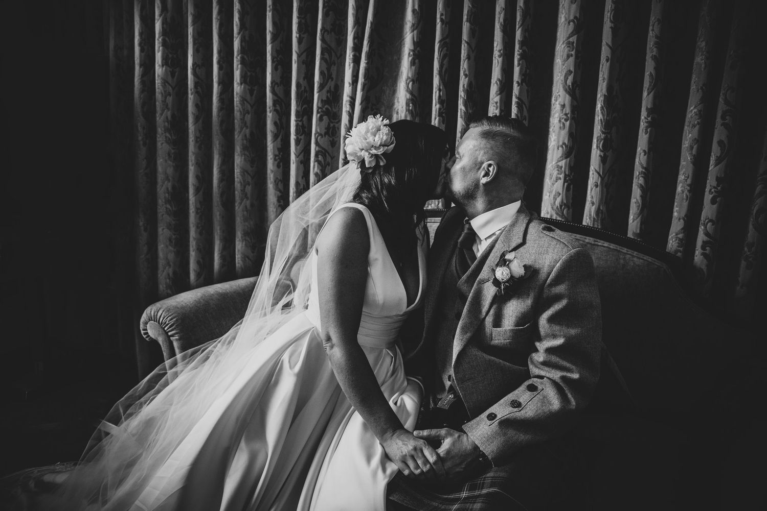 A romantic black and white portrait of newlyweds sharing a tender moment on their wedding day.