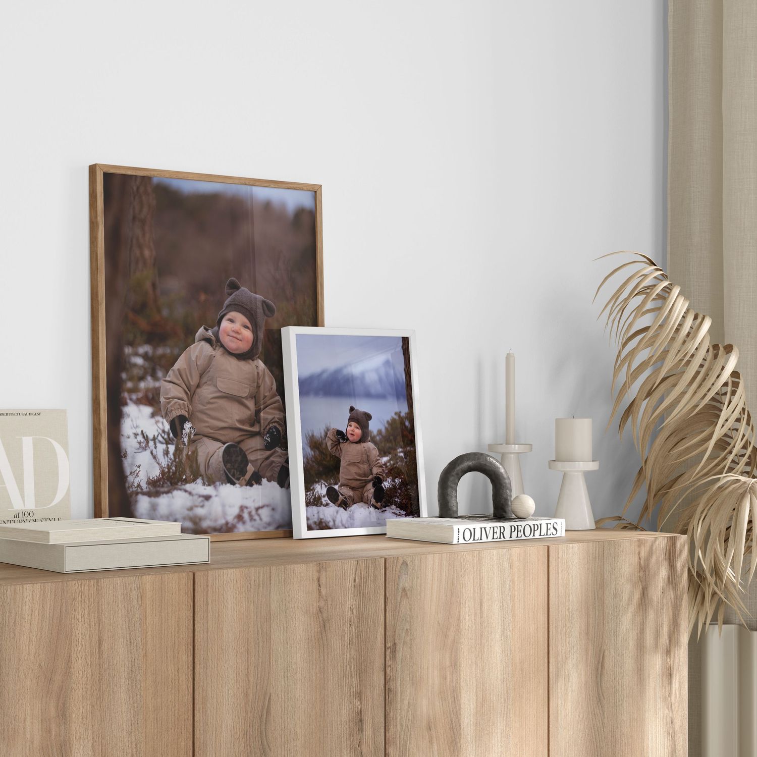 Wooden shelf display with framed photographs and decorative items against white wall.
