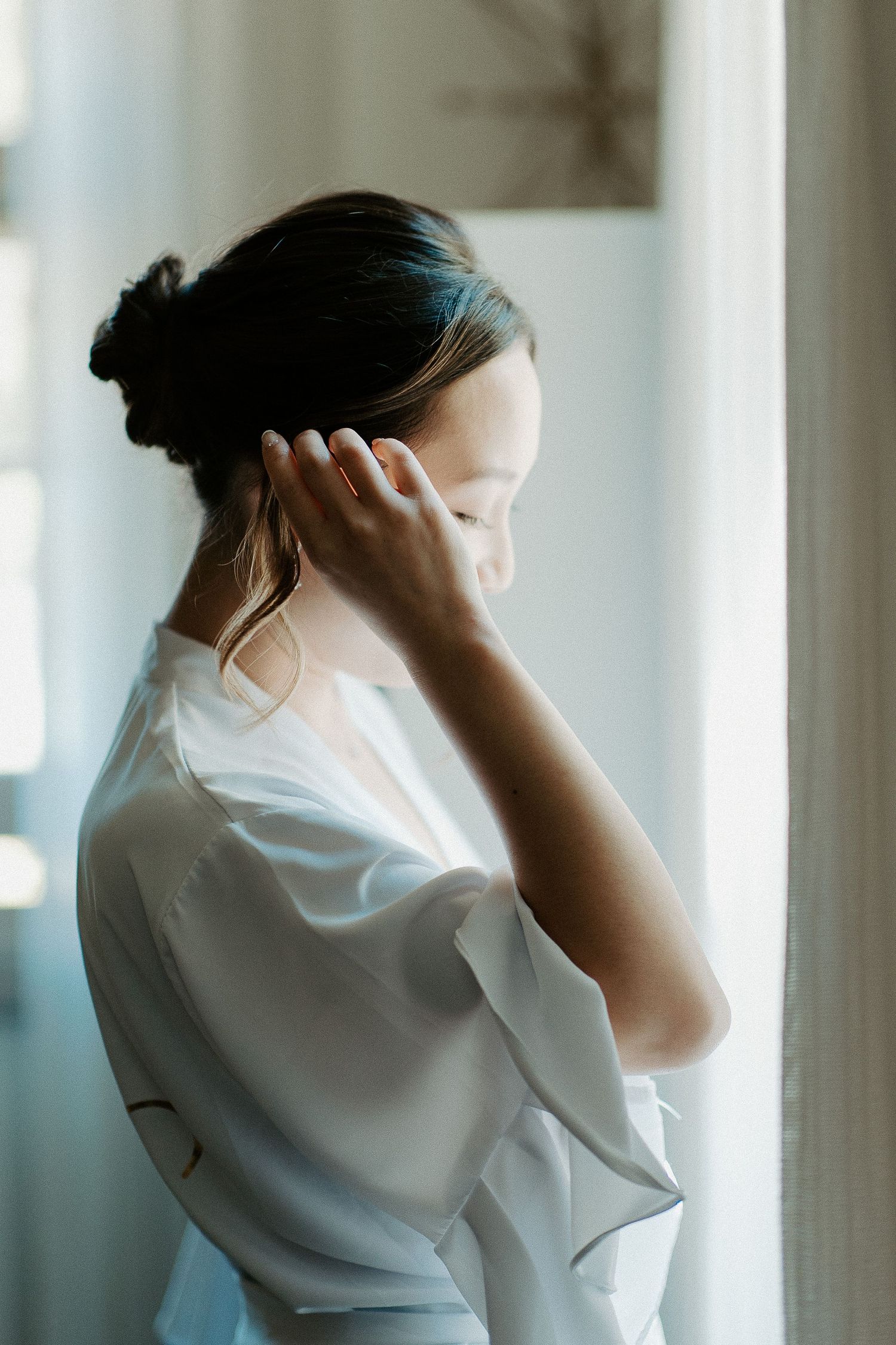 Ethereal morning preparation scene with white robe and window light.