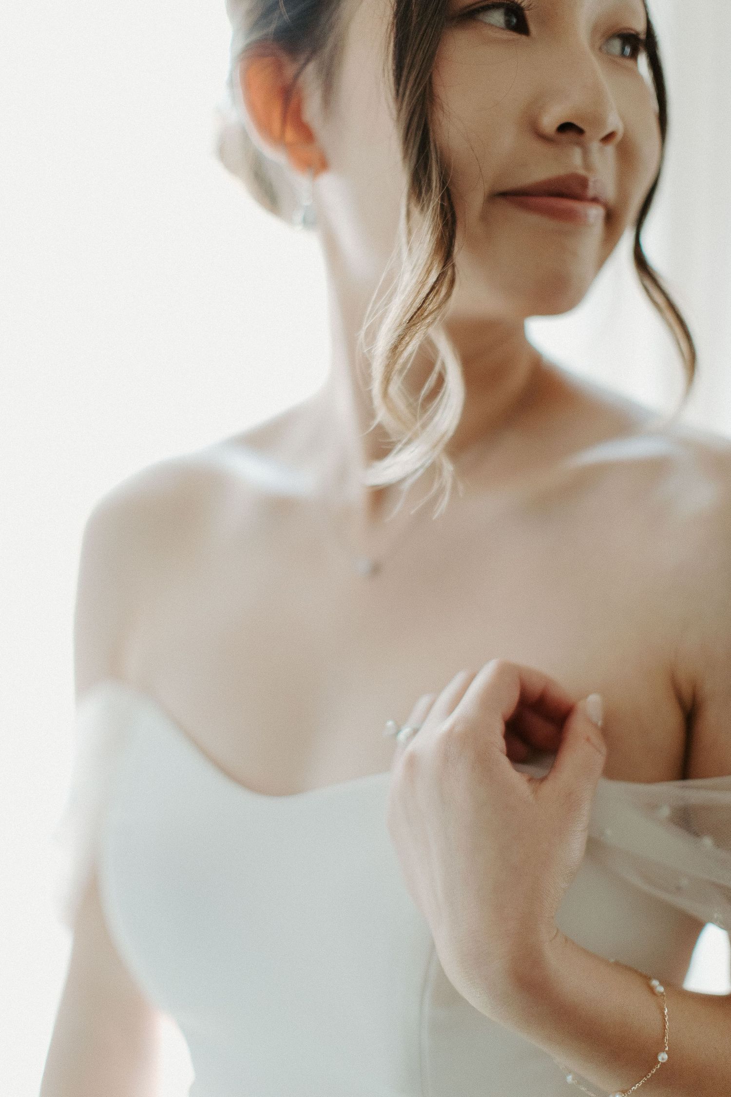 Delicate close-up shot of a white wedding dress with soft natural lighting.